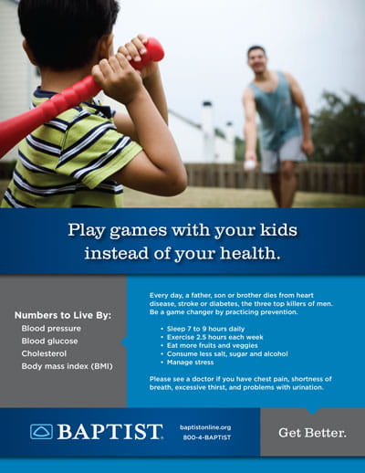 Young boy holds a red plastic bat ready to swing while a man (father) throws a ball in a suburban backyard.