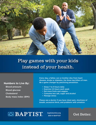 Father tosses a football to a kneeling boy in a grassy park, demonstrating playful father–child activity outdoors.