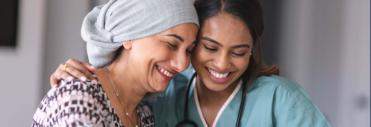 A young woman smiles with a nurse navigator and receives cancer care services at Baptist Cancer Center