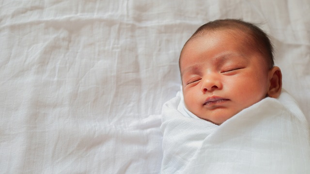 A swaddled baby sleeping.